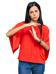 Beautiful young woman wearing casual clothes doing time out gesture with hands, frustrated and...