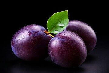 purple plum isolated on a black background. violet fruit, a bunch of berries with leaves.