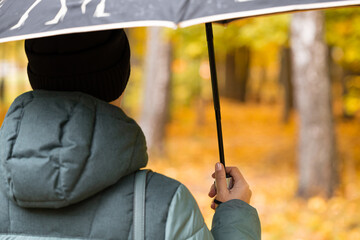 a woman with an umbrella in her hand walks through the autumn park.