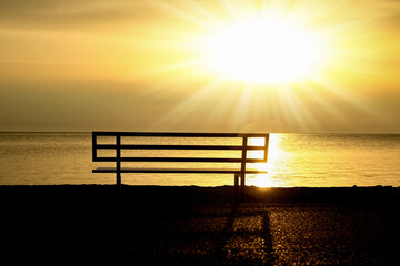 A Sunset by the sea bench in nature travel silhouette