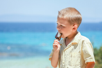 A Happy child boy with ice cream by the sea in nature in the park journey