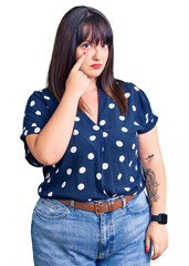 Young plus size woman wearing casual clothes pointing to the eye watching you gesture, suspicious expression