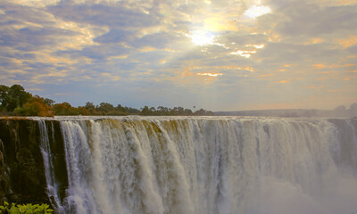 Picturesque celestial landscape with the rays of the morning sun over Victoria Falls.