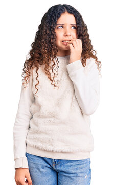 Beautiful kid girl with curly hair wearing casual clothes looking stressed and nervous with hands on mouth biting nails. anxiety problem.