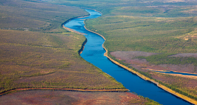 Helicopter view of the autumn Siberian taiga and the Tunguska River with its tributary.