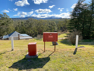 Red metal box of a fire extinguisher in the valley. Old fire hose in a case. Fire hydrant in a...