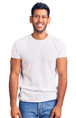 Young latin man wearing casual clothes winking looking at the camera with sexy expression, cheerful...