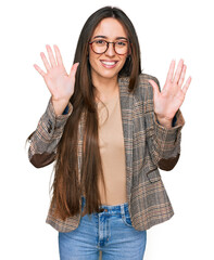 Young hispanic girl wearing business clothes and glasses showing and pointing up with fingers...