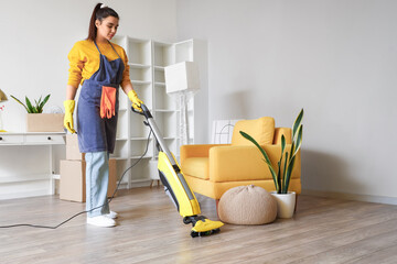 Young woman hoovering floor in her house