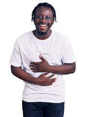 Young african american man with braids wearing casual white tshirt smiling and laughing hard out...
