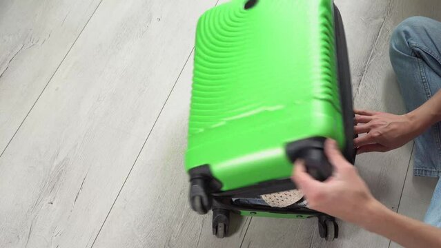 Man packing his suitcase for long journey with wad