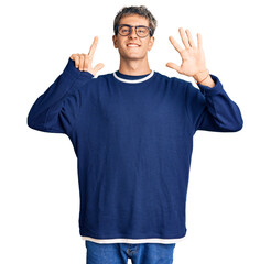 Fototapeta premium Young handsome man wearing casual clothes and glasses showing and pointing up with fingers number seven while smiling confident and happy.