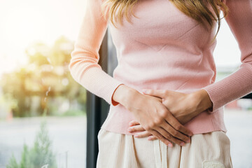 Sad Woman Stomach Ache from menstruation. young female unhappy unwell sick ill hand holding on stomach suffers pain at home, Abdomen bloating and Chronic gastritis concept - obrazy, fototapety, plakaty