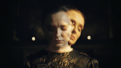 Close-up portrait of a woman with closed eyes on a dark background - obrazy, fototapety, plakaty