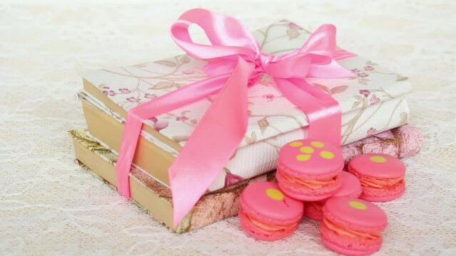 Rose macaroons on table with books wrapped ribbon.