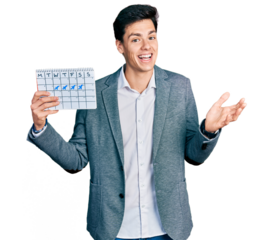 Young hispanic business man holding travel calendar celebrating achievement with happy smile and winner expression with raised hand