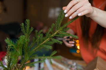 young woman hands wrapping christmas gifts, cropped faceless photo