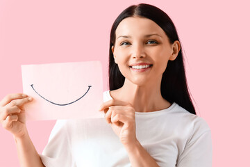 Young woman with paper smile on pink background, closeup - obrazy, fototapety, plakaty