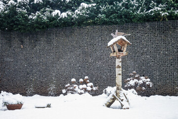 Birdhouse in a backyard with snow.