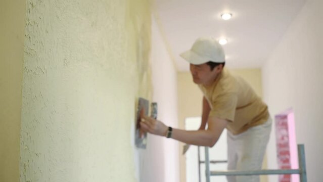Two builders making finish in the apartment with yellow walls.