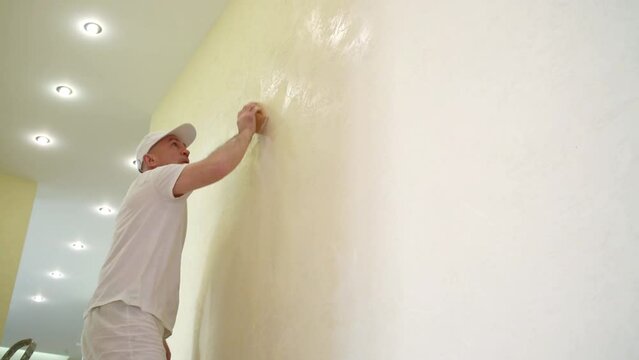 Builder is polishing wall using the sanding sponge.