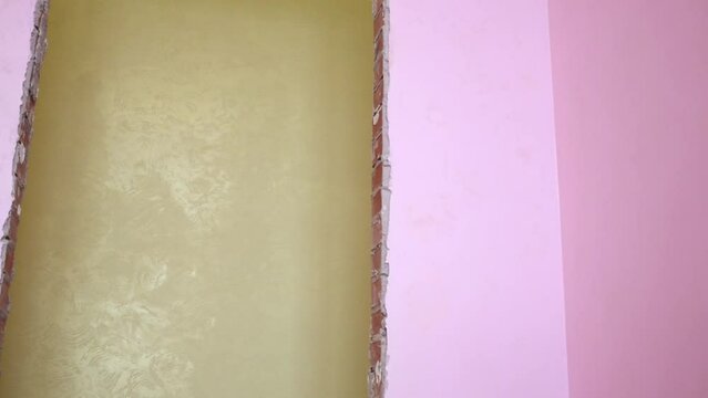 View from pink room of the builder polishing a wall.
