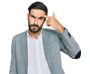 Young hispanic man wearing business clothes pointing unhappy to pimple on forehead, ugly infection...