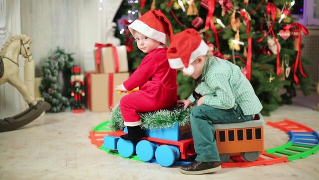 Little boy and girl in Santa costume ride on toy train