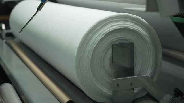 Wind a roll of fabric onto a spool
