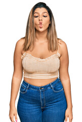 Fototapeta premium Beautiful brunette woman wearing casual clothes making fish face with lips, crazy and comical gesture. funny expression.