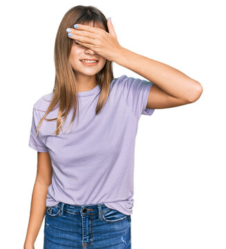 Teenager caucasian girl wearing casual clothes smiling and laughing with hand on face covering eyes for surprise. blind concept.