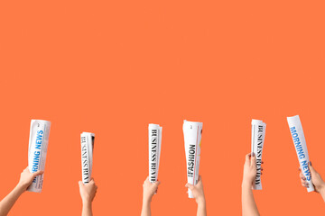 Women with rolled newspapers on orange background