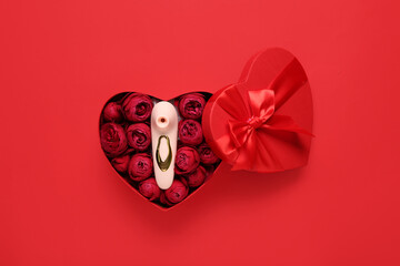 Gift box with beautiful rose flowers and vibrator on red background