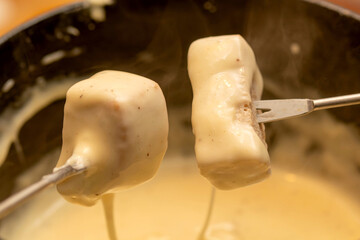 Typisches Schweizer Käsefondue, Essen an einem Winteraben - 710949785