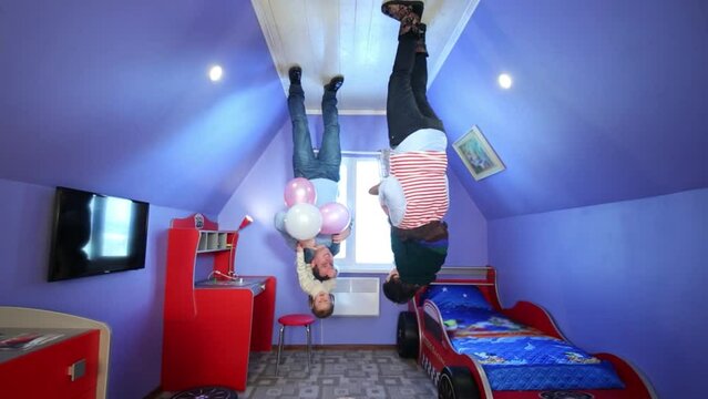 Father, mother and children on ceiling at inverted house