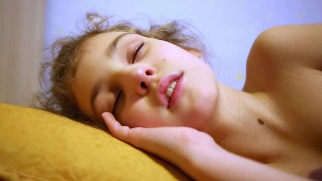 Little girl sleeps, resting his hand under her head.