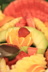 strawberries among several oranges and melons