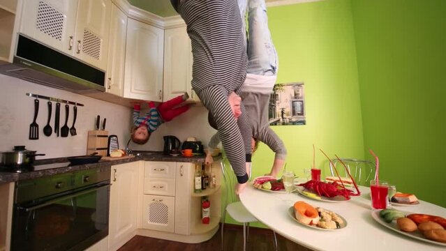 Parents and daughter upside down touch table in inverted house