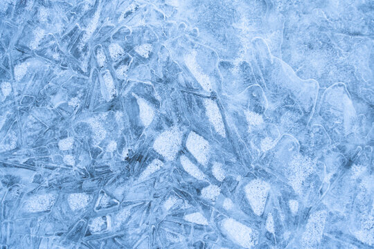 Icy winter background cracked grunge texture. Natural scratched ice on a skating rink as a texture or background for a winter composition, large long painting