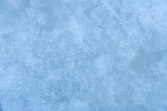 Icy winter background cracked grunge texture. Natural scratched ice on a skating rink as a texture or background for a winter composition, large long painting