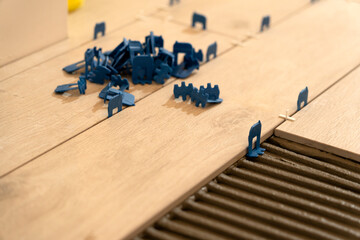 Repair and construction. Laying ceramic tiles using cement on the floor close-up. A man lays slabs on the floor and walls.