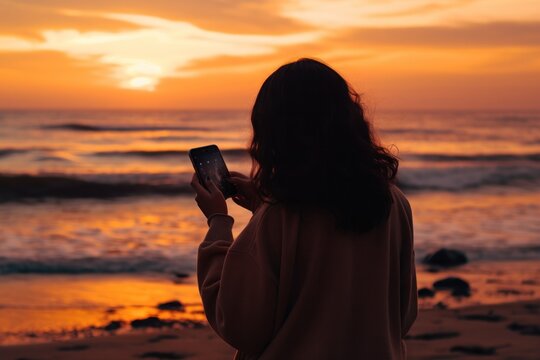 a woman is taking a picture from the beach