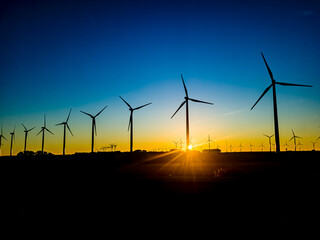 An image of windturbine generator in the field at sunset