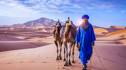 Rolgordijnen Camel rider with camels travelling over dunes in the desert © Eliya