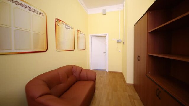 Clean empty room with sofa, bookcases, chairs and yellow walls