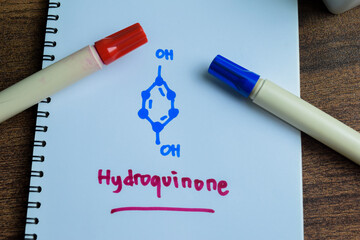 Concept of Hydroquinone molecule write on book isolated on Wooden Table. Structural chemical formula