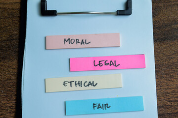 Concept of Moral, Legal, Ethical, Fair write on sticky notes isolated on Wooden Table.