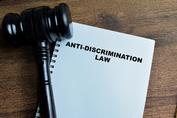 Concept of Anti-Discrimination Law write on book with gavel isolated on Wooden Table.