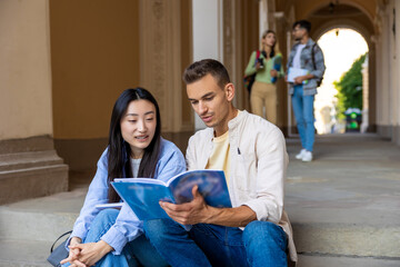 Students sitting on stairs in campus preparing for classes together.
