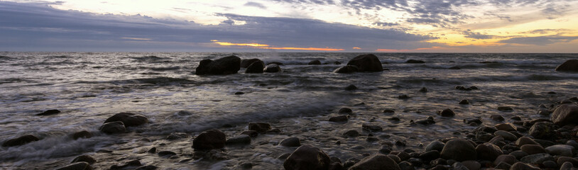 Panoramic view to a scenic coast with rocks by the Baltic Sea at dawn.